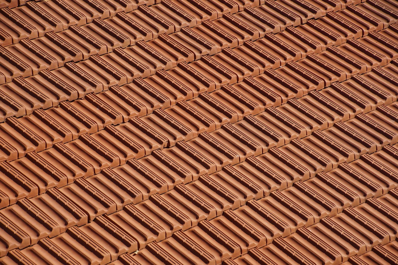 Detailed view of overlapping red clay roof tiles forming a geometric pattern.